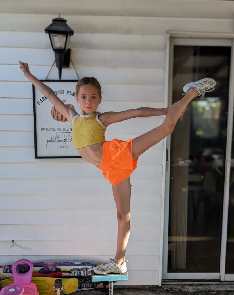 Young Kinsley holding a heel stretch outside